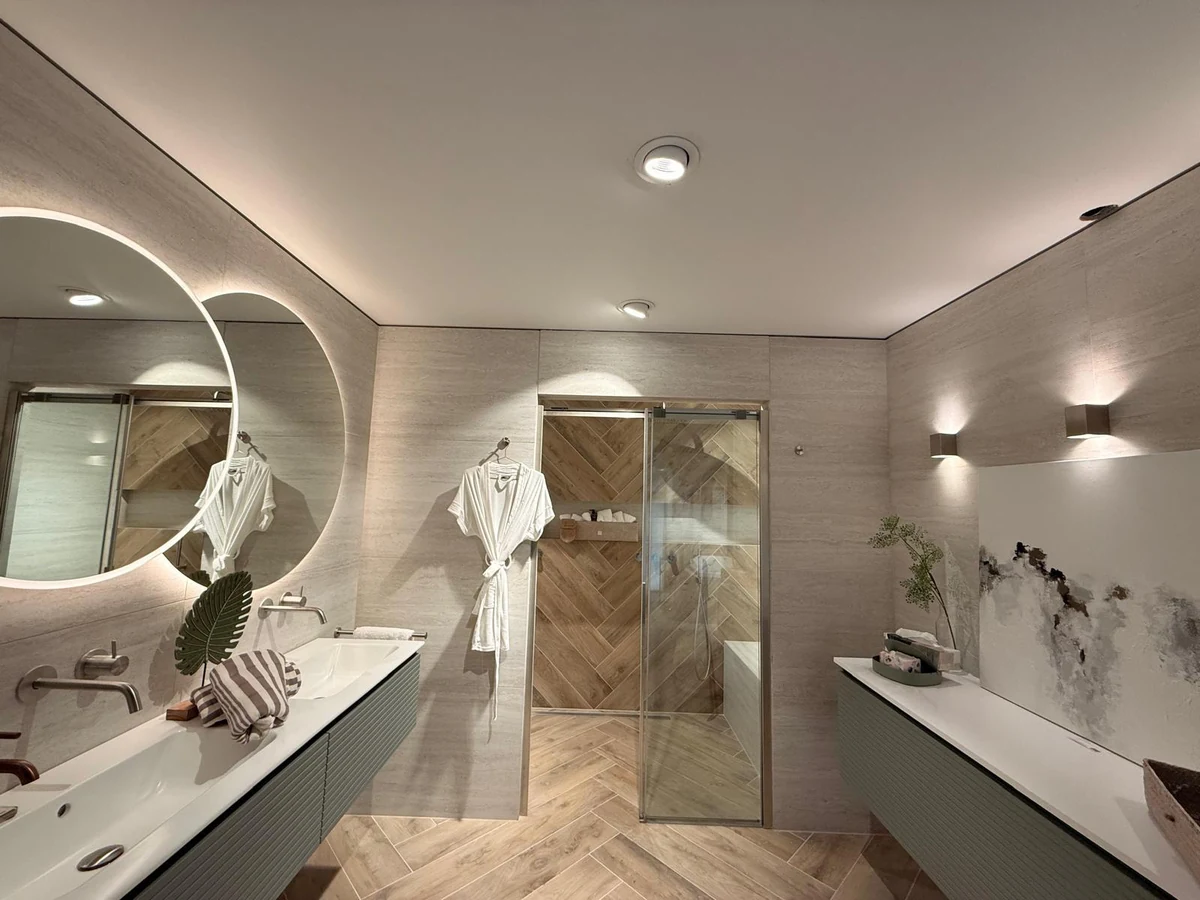 Ruime badkamer met ligbad, dubbele wastafel en douche